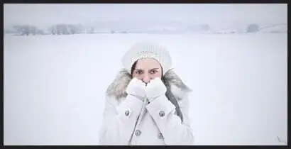 Woman in the snow, cold and needing a warm home with a quality hvac system